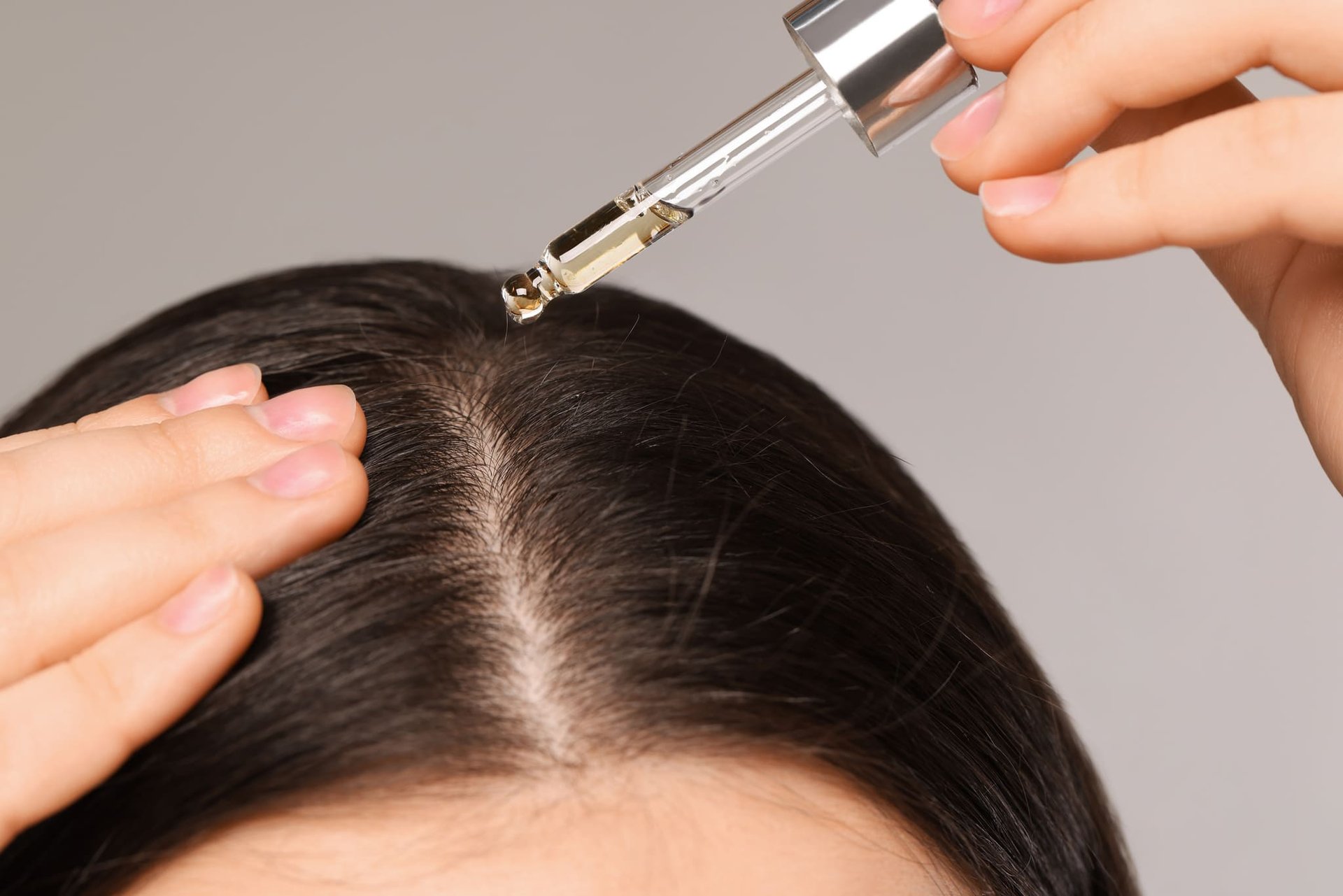 Kobieta nakłada serum na skórę głowy